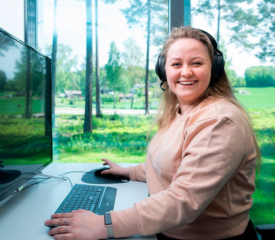 ECIT employee smiling in front of a computer